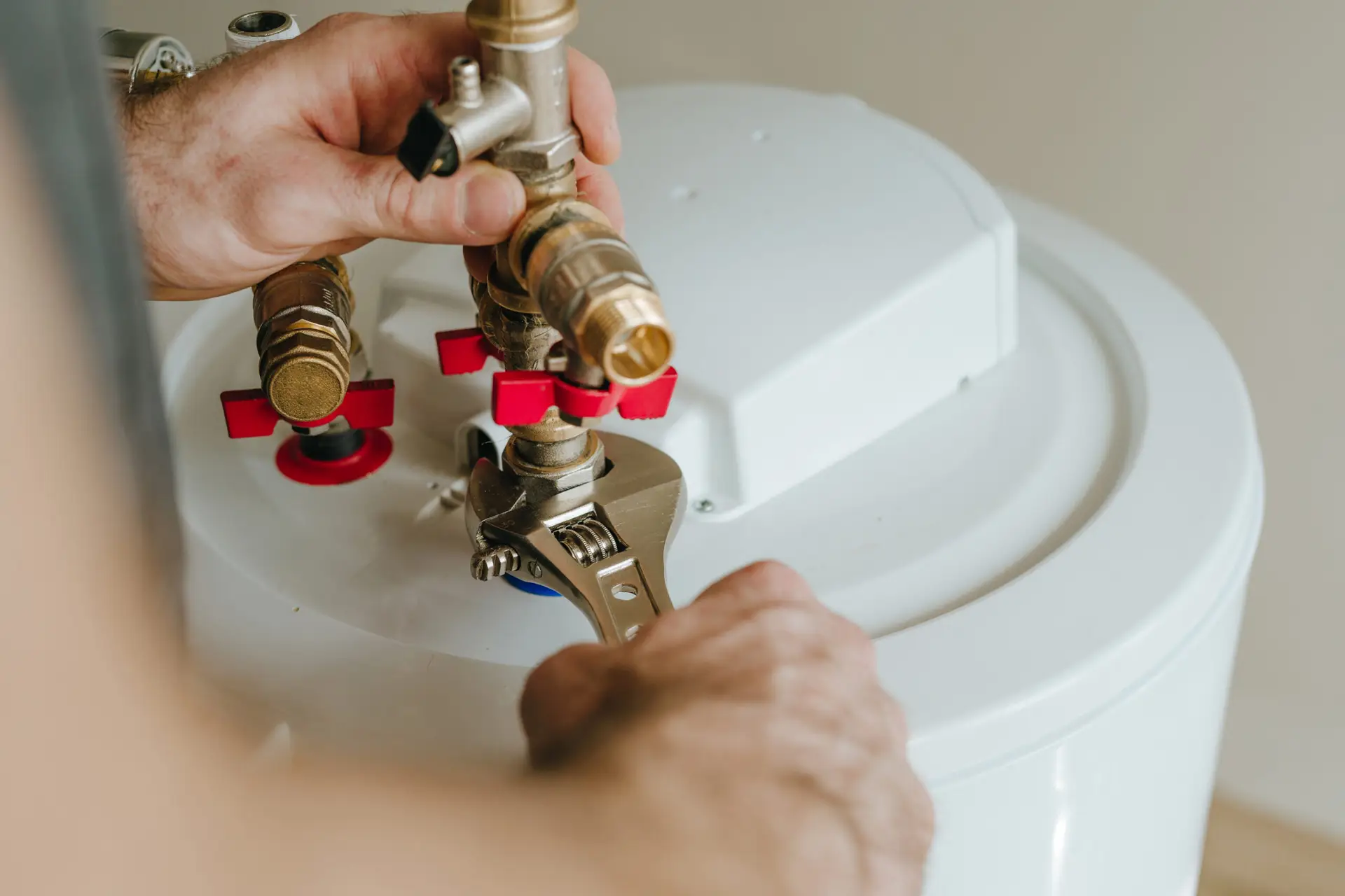 Indianola Mechanical technician installing a plumbing fitting for a water heater